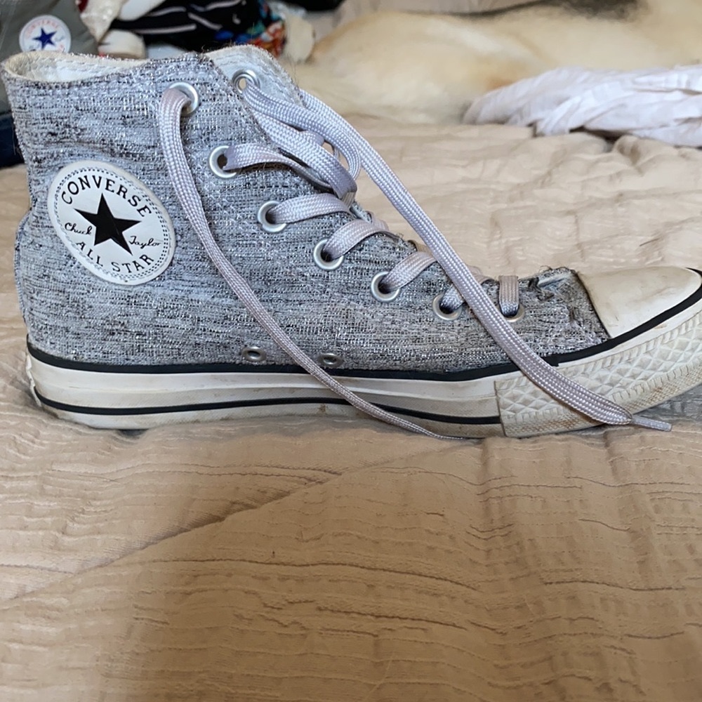 Silver and grey converse high tops.